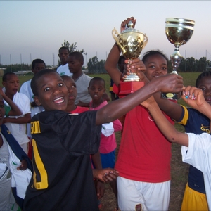 children holding up trophies they won